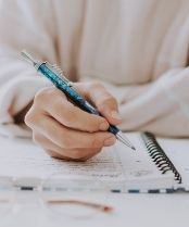 woman's hand writing in a diary to plan ahead